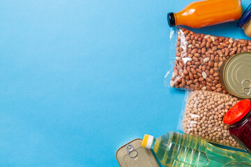 eating, charity and donation concept - close up of different packed food on blue background