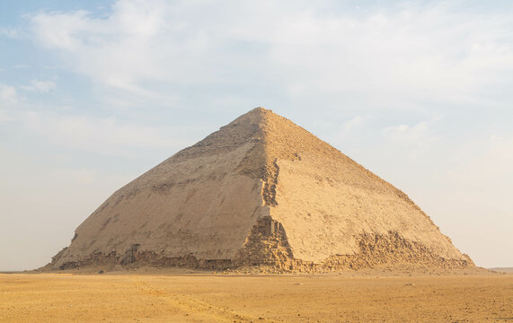 View of Pyramid of Snefru, Bent Pyramid on a blue clouded sky background, at Dahshur, Egypt. The southern pyramid in Dahshur is called cut or diamond-shaped. Cairo, Egypt
