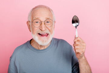 Photo of tricky cunning guy pensioner dressed grey pullover glasses licking lips holding spoon isolated pink color background - obrazy, fototapety, plakaty