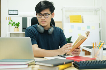 Young man study in front of the laptop computer at home