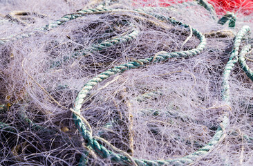 Filet de pêche en nylon violet rangé en tas dans un bac au retour de la pêche en mer.