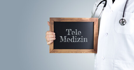 Tele-Medizin. Arzt zeigt Begriff auf einem Holz Schild. Handschrift auf Tafel