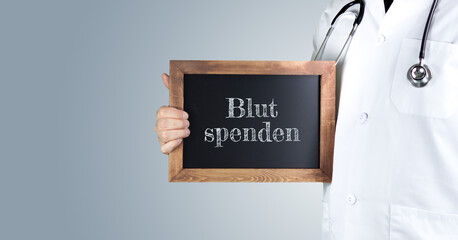 Blut spenden. Arzt zeigt Begriff auf einem Holz Schild. Handschrift auf Tafel