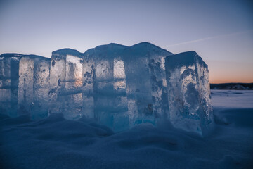 Sunset sky and ice on Lake Baikal. Winter ice on Lake Baikal. Crystal clear water. Ice floes and...