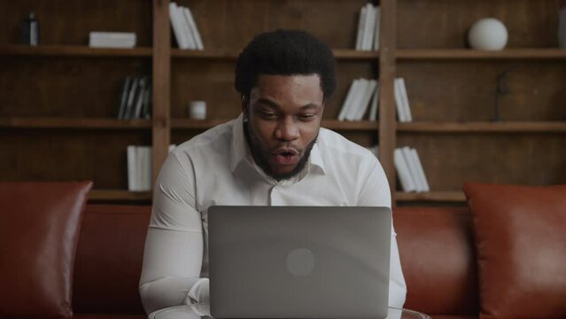 Young adult businessperson recieving good news on his laptop in loft office