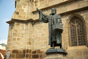 Low-angle shot of the Statue of Honterus outside the church in Brasov, Romania