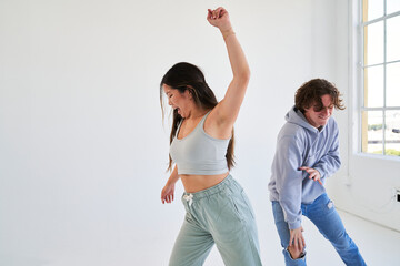 man and woman dancing by bright window