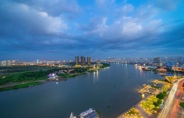 Aerial view of Bitexco Tower, buildings, roads, Thu Thiem 2 bridge and Saigon river in Ho Chi Minh city - Far away is Landmark 81 skyscrapper. This city is a popular tourist destination of Vietnam