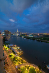Naklejka premium Aerial view of Bitexco Tower, buildings, roads, Thu Thiem 2 bridge and Saigon river in Ho Chi Minh city - Far away is Landmark 81 skyscrapper. This city is a popular tourist destination of Vietnam