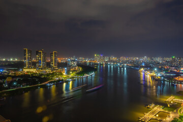 Fototapeta premium Aerial view of Bitexco Tower, buildings, roads, Thu Thiem 2 bridge and Saigon river in Ho Chi Minh city - Far away is Landmark 81 skyscrapper. This city is a popular tourist destination of Vietnam