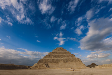 Fototapeta na wymiar Majestic View to the Step Pyramid of Djoser under blue sky, is an archaeological site in the Saqqara necropolis, northwest of the city of Memphis, Egypt