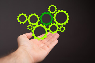 Mechanism green gears and cogs at work on black background. Industrial machinery. 3D illustration. 3D high quality rendering.