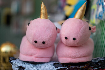 Close-up shot of unicorn baby slippers in a blurry background.