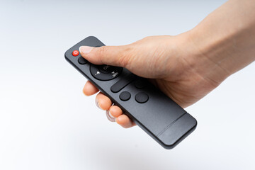 Asian hand operating remote control on white background © HYEJIN