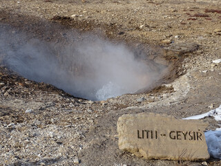 Hot steam coming out from the ground in the great Geysir on a sunny winter day in South Iceland