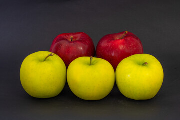 Yellow and red apples on a black background