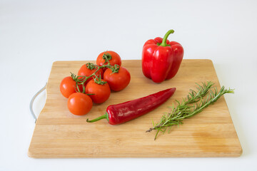 Vegetables on a wooden background, peppers and tomatoes, greens