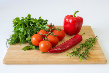 Vegetables on a wooden background, peppers and tomatoes, greens