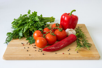 Vegetables on a wooden background, peppers and tomatoes, greens