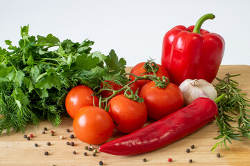 Vegetables on a wooden background, peppers and tomatoes, greens
