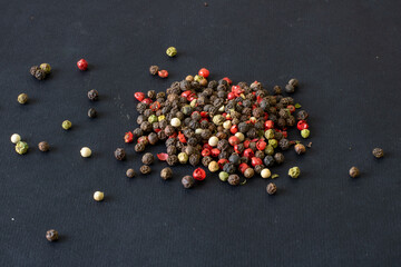 Peppercorns on a black background, peppercorns of different colors