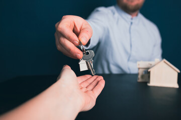 Female hand taking key from realtor buying renting new house, getting real estate ownership concept.