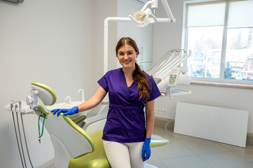 portrait of friendly happy female dentist in uniform and waiting patient at modern clinic