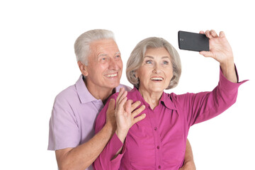 Portrait of a happy senior couple taking selfie photo at white background