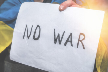 No war written on a poster that a man holds in Ukraine