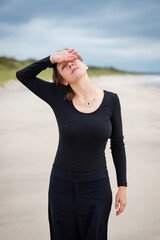 
Relaxed woman on the beach in black danger
