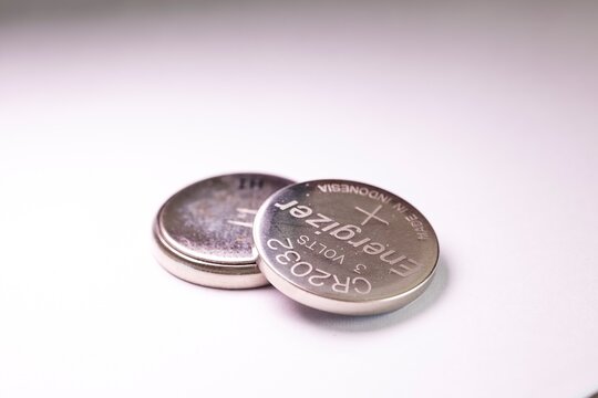 Brecht, Belgium - March 5 2022: A studio portrait of two button cell, coin or watch Energizer batteries stacked on top of each other. The tiny single use power supplies are ready for use.