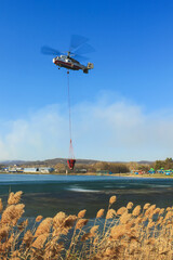 Helicopter KA-32 Ministry of Emergency Situations takes water from the lake, to extinguish a forest...