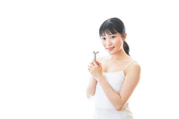 かっさで肌をマッサージをする若い女性