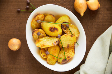 Love at first bite. Overhead shot of roasted potatoes in a white serving bowl.