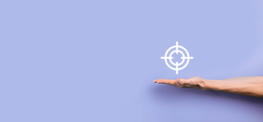 Targeting concept with businessman hand holding target icon dartboard sketch on chalkboard. Objective target and investment goal concept.