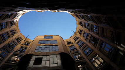 Low angle of a an oval shape building with view of sky