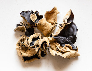 several dried chinese black wood ear fungus on gray plate close up