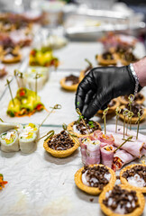 Chef hand is in process of Preparing catering food on table