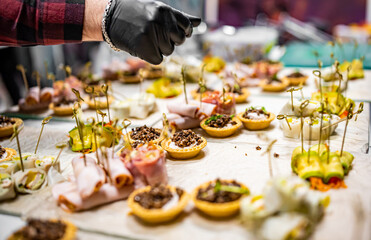 Chef hand is in process of Preparing catering food on table