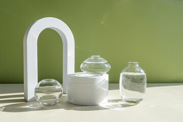 Interior still life with a geometric figure, shadows and sunlight. Composition in a minimalist style. Vase with decorative elements on a green background.