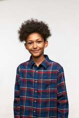 Vertical image of cute adorable school boy of 12 dressed in plaid shirt having funny fluffy afro...