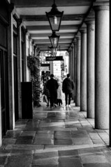 Vertical shot of people walking near a hotel, Covent Gardens, London, grayscale image