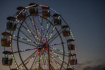 Beautiful view of Ferris wheel with lights in the evening