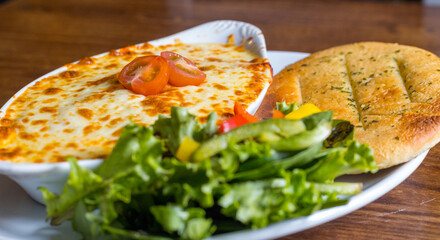 Closeup shot of Cannelloni with Garlic Flatbread and salad