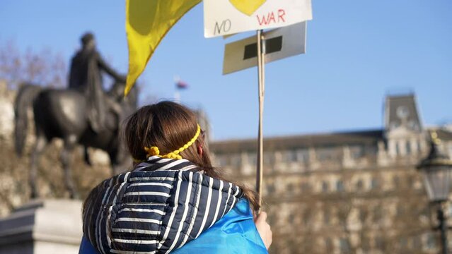 London stands with Ukraine, child protesting waving sign of peace, protester in Trafalgar Square in London during protest against war with Russia