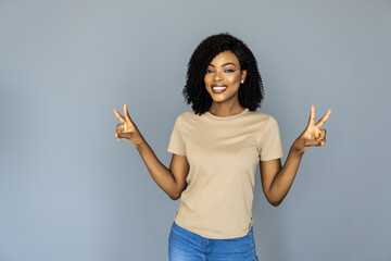 Cheerful young african woman with peace isolated on grey background