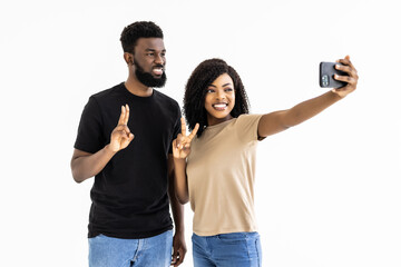 Portrait of a two joyful young african couple taking a selfie isolated over white background