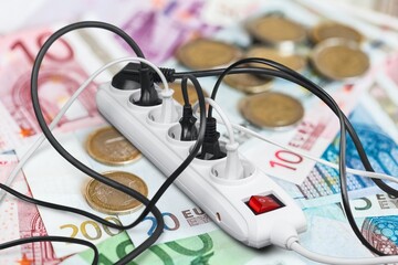 An electric cable and money banknotes. expensive electricity