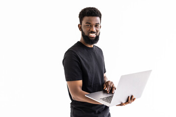 Young smiling african man standing and using laptop computer isolated over white background