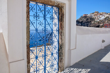 An external decorated door of a villa and view  of the Fira and the  aegean sea in  Santorini